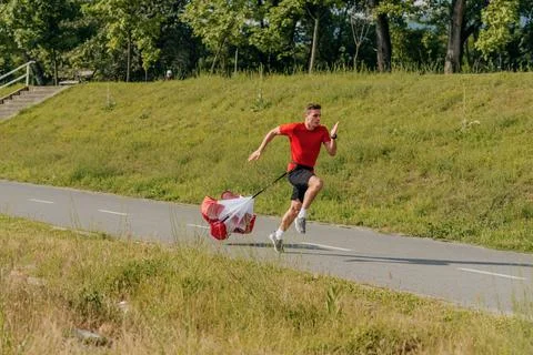 Side view of a strong man doing workout using resistance parachute outdoors 写真素材