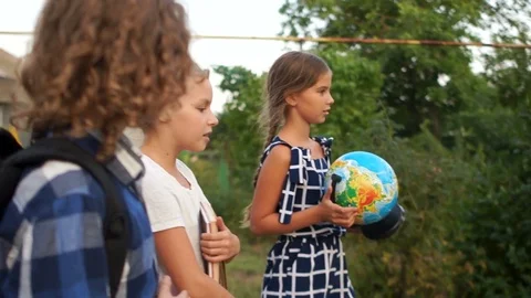 Side view. Students go to school in the village on a country road. Studying in Stock Footage 114060061