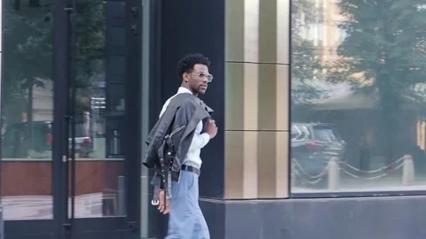 Side view stylish man walks outside and wears trendy clothes, blue pants and Stock Footage 255134866