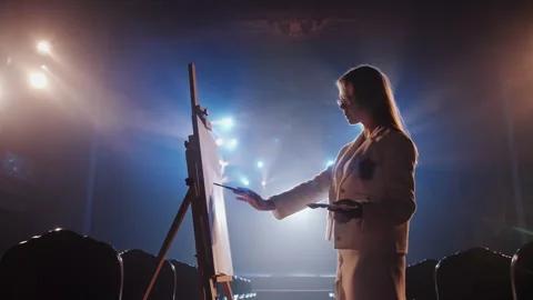 Side View of Stylish Young Female Artist in Glasses Painting on Easel 库存影片 336334548