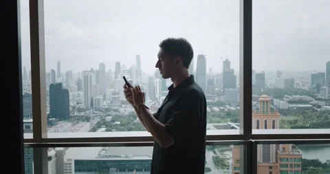 Side view successful entrepreneur using smartphone while standing on balcony Stock Footage 249823352