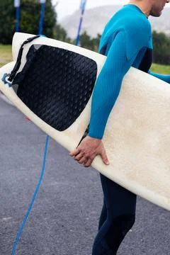 Side View of Surfer with Surfboard Heading Out Stock Photos