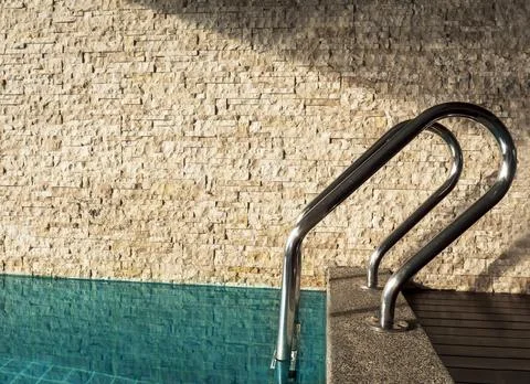 Side view of swiming pool handles near brick wall in hotel room. Close up poo Stock Photos