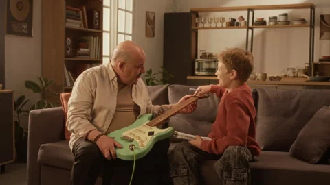 Side View of Teacher Explaining Electric Guitar to Smiling Young Boy Stock Footage 333424826