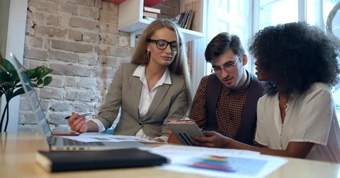 Side view of the team work of three multirace businesspeople discussing problems Stock Footage 84041306