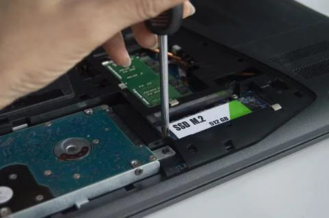Side view of technician installing M.2 SSD hard drive. Stock Photos