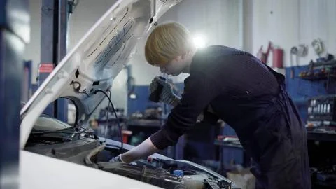 Side view of technician making maintenance of the car in garage Stock Photos