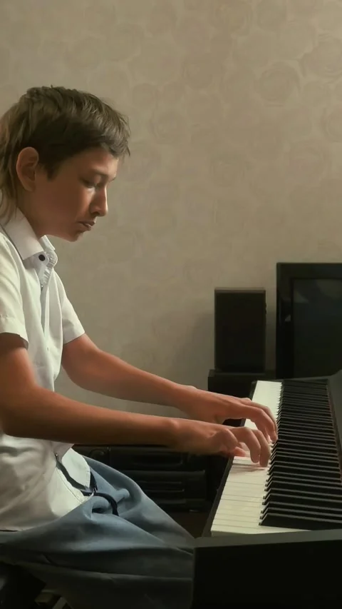 Side view of teenager playing electronic piano keyboard during music practice an Stock Footage 336302254