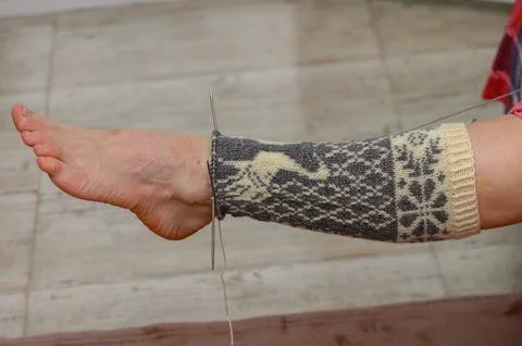 Side view of testing a long knitted stocking with a deer pattern on a foot Stock Photos