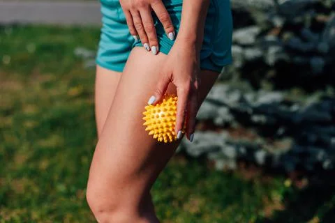 Side view of thin athletic body of a young woman doing hip massage with spiky Stock Photos