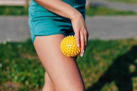 Side view of thin athletic body of a young woman doing hip massage with spiky Stock Photos