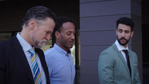 Side view three diverse serious business men communicating walking outdoors. Co Stock Footage 252542431