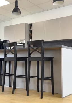 Side view of three tall black wooden bar stools near kitchen island Stock Photos