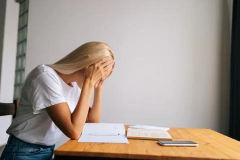 Side view of tired blonde young woman massaging temples, suffering from headache Stock Photos