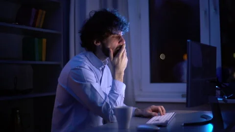 Side view of tired sleepy man yawning and rubbing eyes during working on Stock Footage 146388260