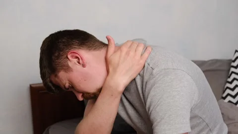 Side view of tired young man  feels pain in neck in morning after sleeping Stock Footage 130641255