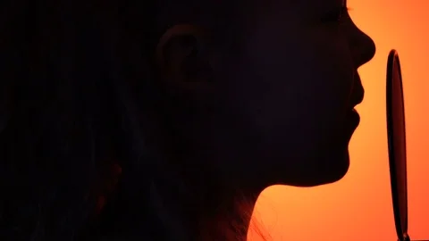 Side view tracking close-up shot of cute little girl silhouette singing with a Stock Footage 75183248