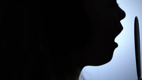 Side view tracking close-up shot of cute little girl silhouette singing with a Stock Footage 75194842