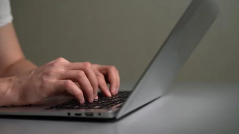 Side view tracking shot of male hands typing on modern laptop keyboard. Concept Stock Footage 342761708