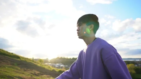 Side View Tracking Shot of Young Asian Man Struggling to Hike Up Hill Stock Footage 121082644