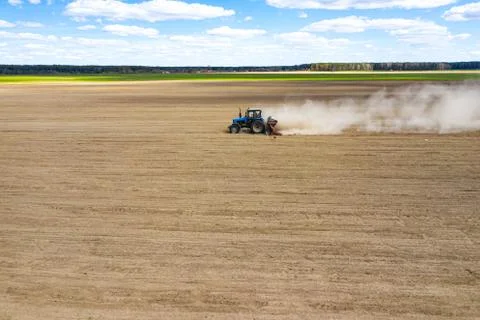 Side view of tractor planting corn seed in field, high angle view drone photo Stock Photos