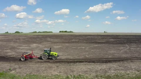 Side view of a tractor plowing the ground Video stock 209936837