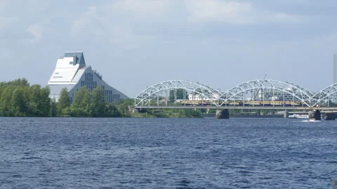Side View of Train Bridge with Passing Train and View of Latvian National Stock Footage 311936792