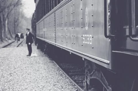 Side View of a Train at a Stop with the Conductor Standing By Fotos Stock
