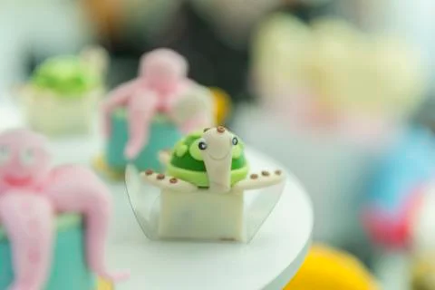 Side view of turtle shapes personalized candy on a green turquoise background Stock Photos