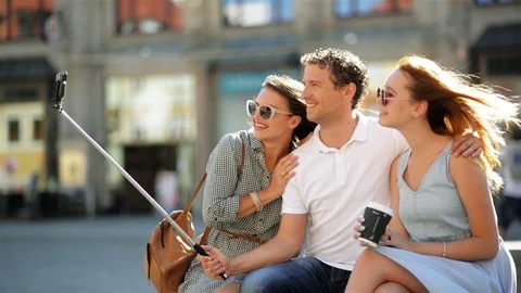 Side View of Two Beautiful Girls and One Handsome Boy Taking Selfie Using Stock Footage 79861811