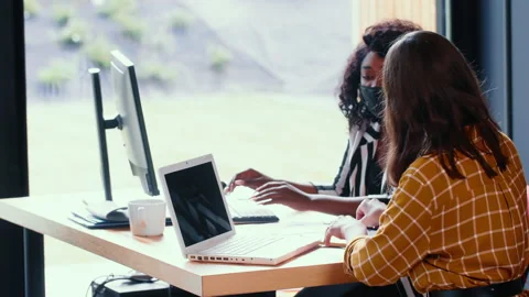 Side view two beautiful happy multiethnic business women work together at office Video stock 141754099