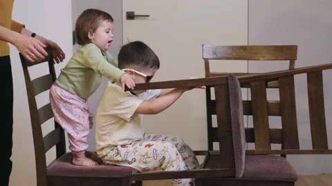 Side view of two children having fun and ride in a chair construction at the Stock Footage 168597718