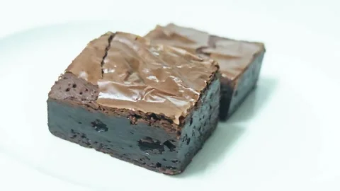Side view of two chocolate brownie squares on a white plate. Stock-Footage 345338634