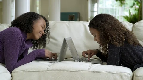 Side view of two girls laying on sofa using their laptops. 스톡 동영상 88174795