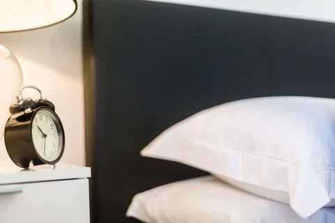 Side View of a Two Pillows Kept on a Bed and an Alarm Clock on Top of a Side  Stock Photos