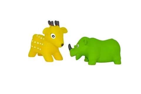 Side view of two rubber toy of a yellow colored deer and a green colored rhin Stock Photos