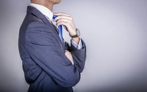 Side view on unknown man adjusting blue necktie Foto stock