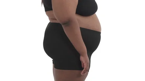 Side view of unrecognizable african obese woman's body in underwear shaking her Stock Footage 134595474