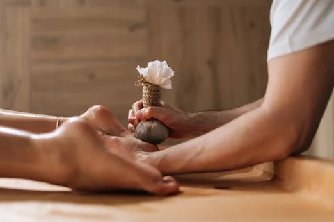 Side view of unrecognizable relaxed young woman getting Ayurvedic feet massage Stock Photos