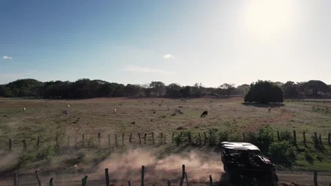 Side view of UTV riding through rural fence trail in Costa Rica Stock Footage 311036462