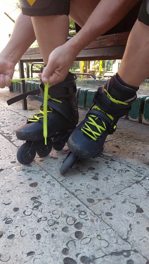 Side View Vertical 4K Close Up of Man Tying Laces on Right Inline Skate Stock Footage 346075960