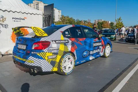 Side view of a vibrant, sponsored racing car at an outdoor automotive event o Stock Photos