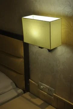 Side view of wall light lamp near to bed   Stock Photos