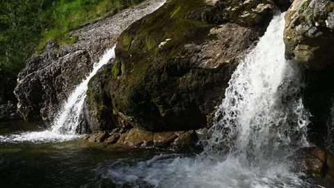 Side view of waterfalls splashing into a pond in the evening summer sun 스톡 동영상 260819161