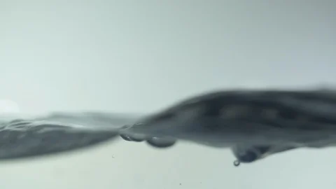 Side view of waves from a drop of water on surface of water in aquarium Stock-Footage 105237614