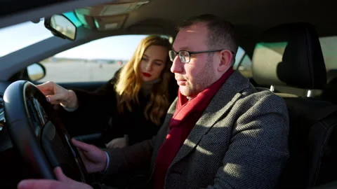 Side view of wealthy stylish Caucasian man sitting on driver's seat in car with Stock Footage 148763526