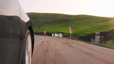 Side view wheel spin in fast motion on standard grey asphalt surface uphill i Видео 198377687