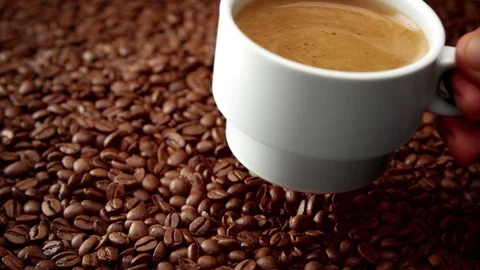 Side view of white cup of black coffe on coffee beans Stock Footage 86292482