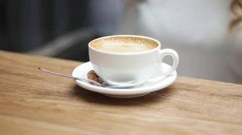 Side view of white cup of black coffe on light wooden table background. Media Stock Photos