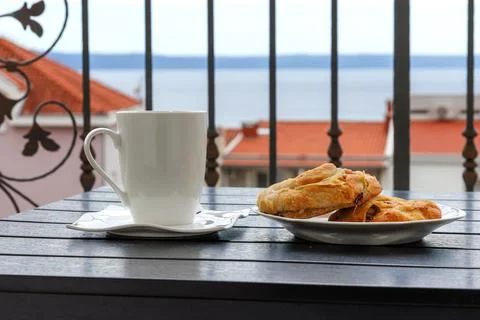 Side view of a white cup of tea and  plate with burek pastry on a balcony t.. Stock Photos